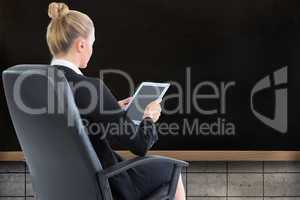 Composite image of businesswoman sitting on swivel chair with ta