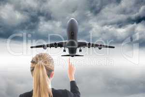 Composite image of businesswoman pointing somewhere