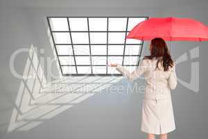 Composite image of businesswoman holding umbrella