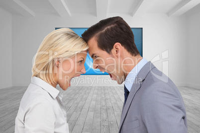 Composite image of colleagues quarreling head against head