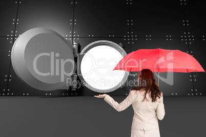 Composite image of businesswoman holding umbrella