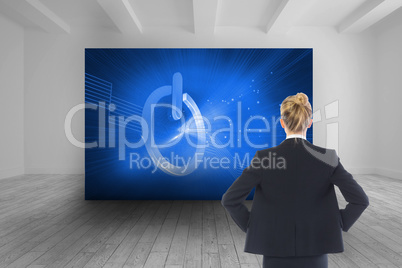 Composite image of businesswoman standing with hands on hips