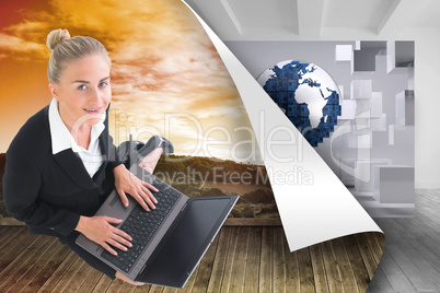 Composite image of businesswoman using laptop