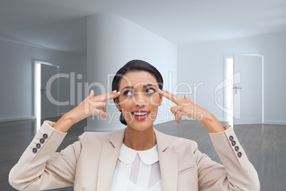 Composite image of confident young businesswoman pointing her he