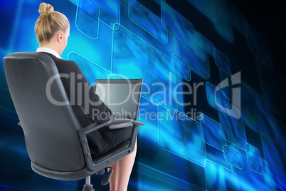 Composite image of businesswoman sitting on swivel chair with la