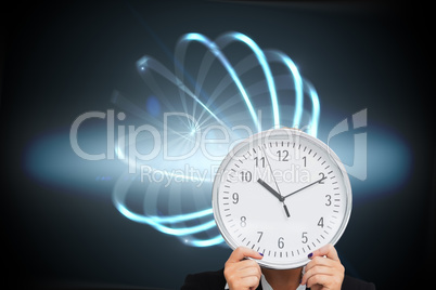 Composite image of businesswoman in suit holding a clock