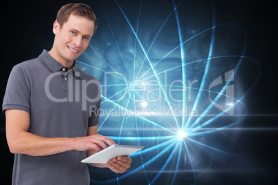 Composite image of smiling young man with tablet computer