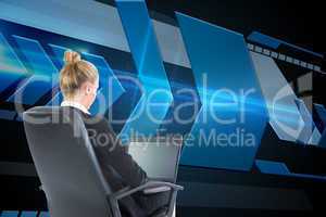 Composite image of businesswoman sitting on swivel chair with la