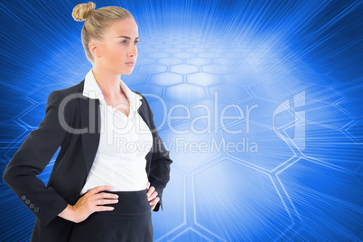 Composite image of businesswoman standing with hands on hips