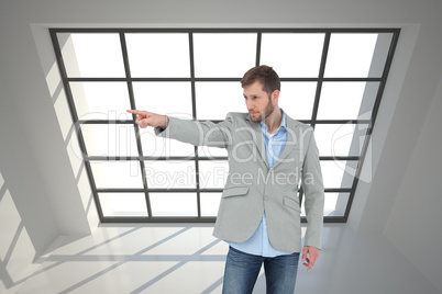 Composite image of trendy model pointing to something