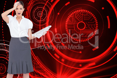 Composite image of shocked classy businesswoman holding newspape