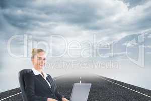 Composite image of businesswoman sitting in swivel chair with la