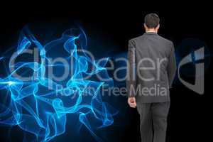 Composite image of young businessman walking away from camera