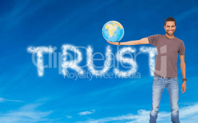 Composite image of handsome man holding out a globe