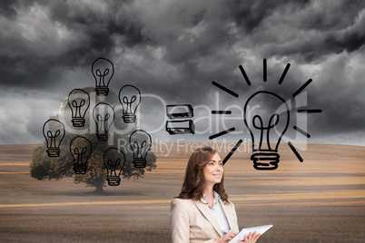 Composite image of businesswoman holding tablet and looking up