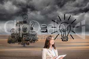 Composite image of businesswoman holding tablet and looking up