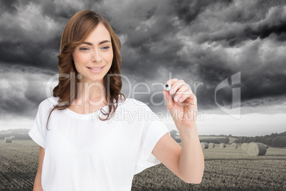 Composite image of smiling businesswoman holding marker