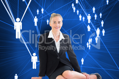 Composite image of young businesswoman sitting on ground