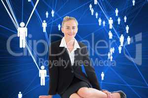 Composite image of young businesswoman sitting on ground