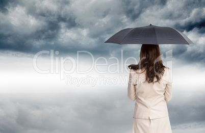 Composite image of rear view of classy businesswoman holding umb Composite image of rear view of classy businesswoman holding umb