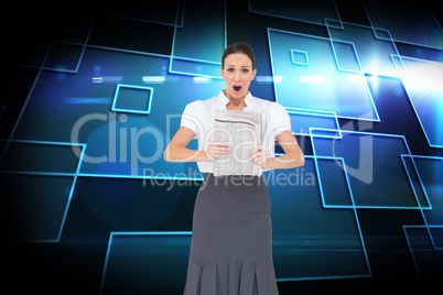 Composite image of shocked stylish businesswoman holding newspap Composite image of shocked stylish businesswoman holding newspap