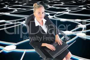 Composite image of businesswoman sitting on swivel chair with la