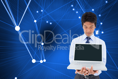 Composite image of businessman showing a laptop