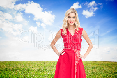 Composite image of smiling blonde standing hands on hips