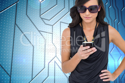 Composite image of happy brunette using smartphone