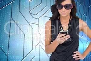 Composite image of happy brunette using smartphone