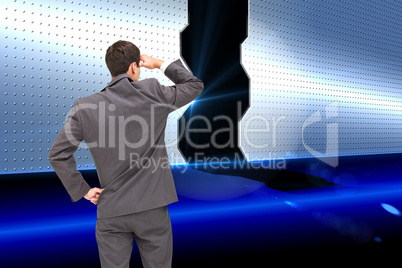 Composite image of businessman standing hand on hip