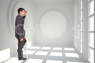 Composite image of happy businessman standing on ladder