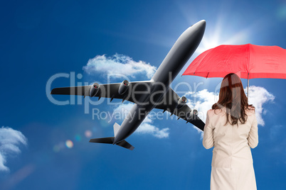 Composite image of businesswoman standing back to camera holding