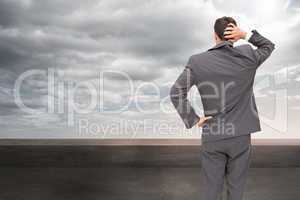 Composite image of young businessman standing back to camera scr