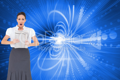 Composite image of shocked stylish businesswoman holding newspap