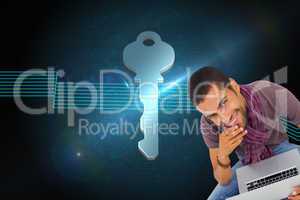 Composite image of thoughtful man sitting on floor using laptop