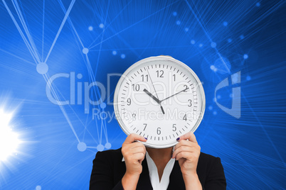 Composite image of businesswoman in suit holding a clock