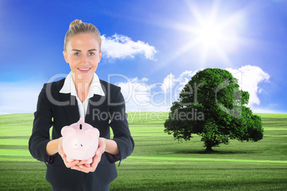 Composite image of businesswoman holding pink piggy bank