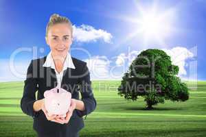 Composite image of businesswoman holding pink piggy bank