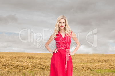 Composite image of elegant blonde standing hands on hips