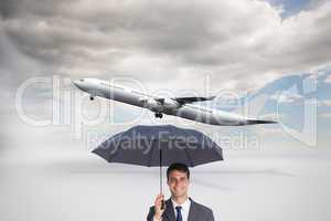 Composite image of happy businessman holding grey umbrella