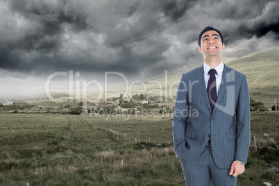 Composite image of smiling businessman standing