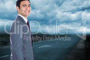 Composite image of smiling businessman standing