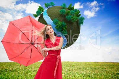 Composite image of elegant blonde holding umbrella