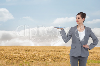 Composite image of businesswoman holding tablet computer