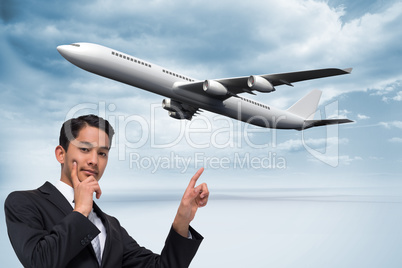 Composite image of thoughtful asian businessman pointing