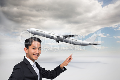 Composite image of smiling asian businessman pointing