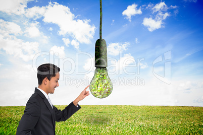 Composite image of smiling asian businessman pointing