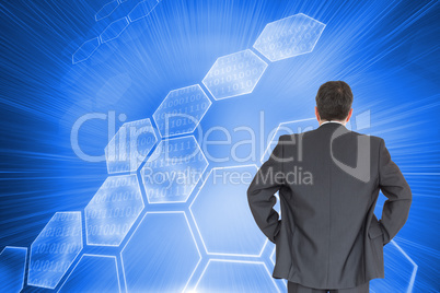 Composite image of businessman standing back to the camera with