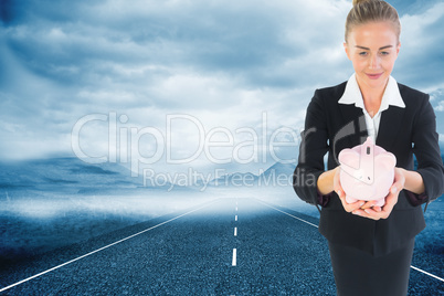 Composite image of businesswoman holding pink piggy bank